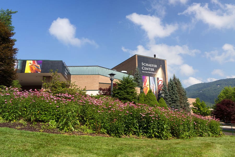 A large building with flowers in the foreground.