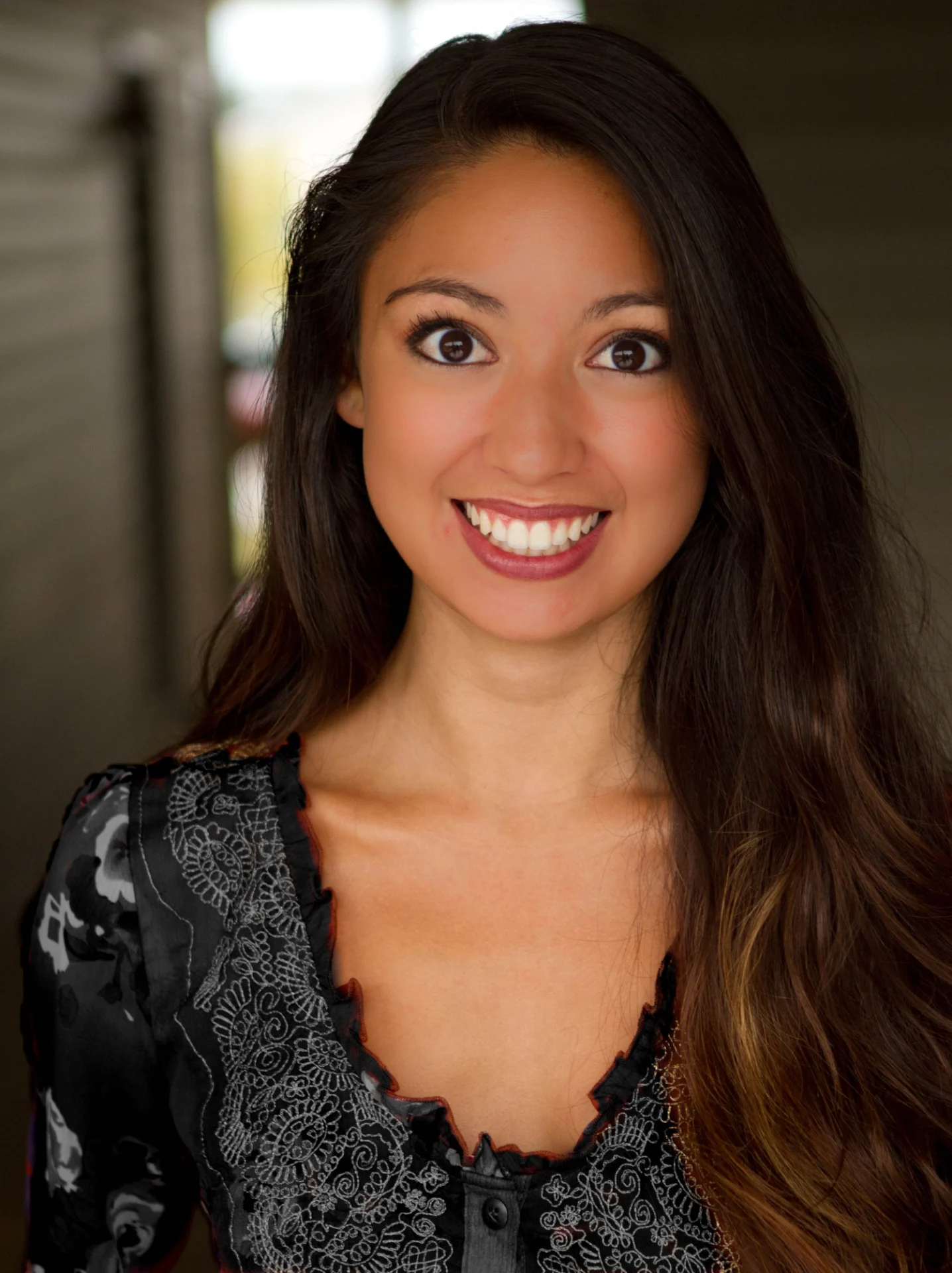 A woman with long hair and a smile.