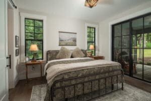 Cozy bedroom with large windows and lamps.