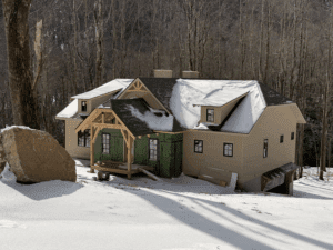 House in snowy forest setting, winter scene.