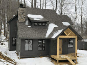 Snow-covered cabin in winter forest setting.